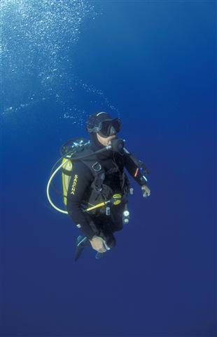 Plongeur expérimenté en immersion profonde dans les eaux cristallines de Hyères, équipé pour une exploration sous-marine.
