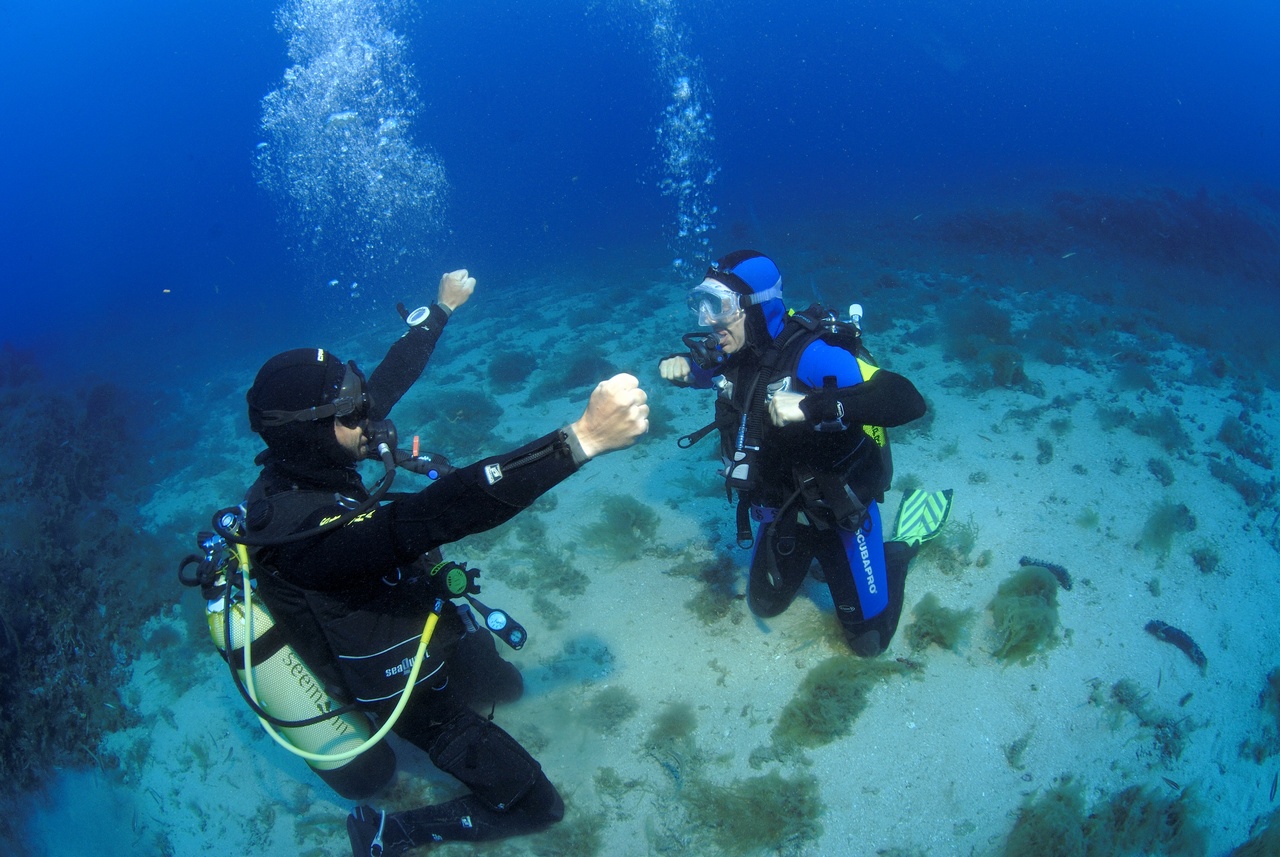 Deux plongeurs sous l'eau en formation, apprenant les bases de la plongée à Saint-Tropez